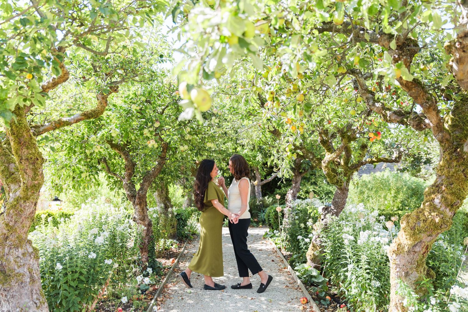 A lush garden pathway with apple trees at Lords of the Manor in The Cotswolds - female couple engagement photographs