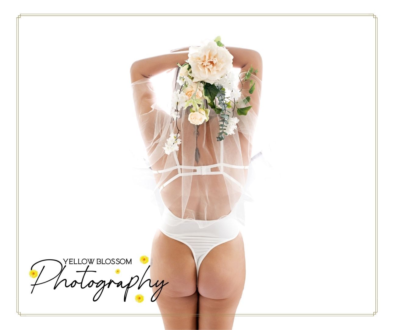 Artistic boudoir photography featuring white lingerie and a delicate bouquet of cream roses against a light background.