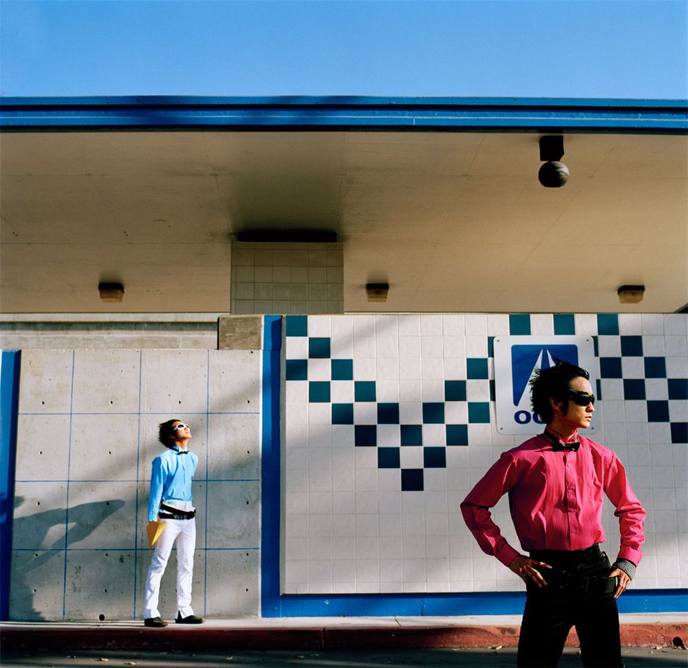 Los Angeles Brand Photographer. Two men in front of Minimalist architectural composition with blue and white geometric patterns on wall.