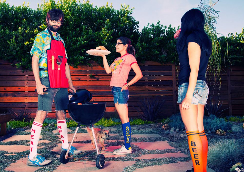Los Angeles Brand Photographer. People grilling outdoors in a backyard with green foliage in the background.
