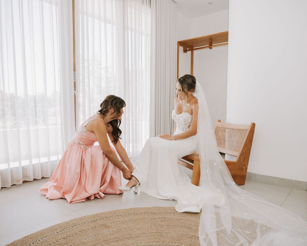 A collage of four photos showing someone in a pink dress sitting on a light colored floor near white curtains.