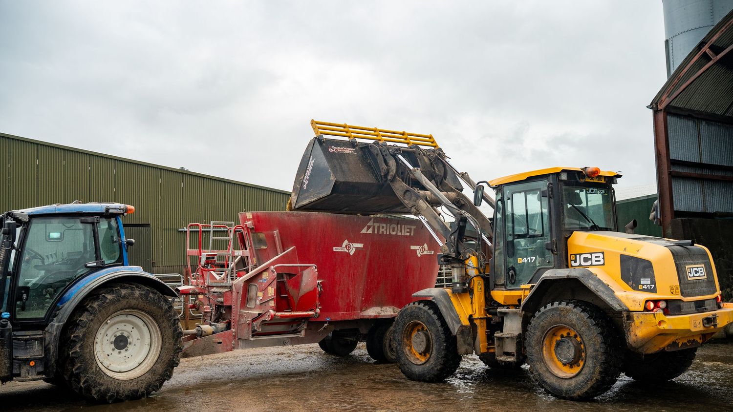 Heavy construction equipment and machinery including dump trucks, tractors and loaders lined up at an industrial site.