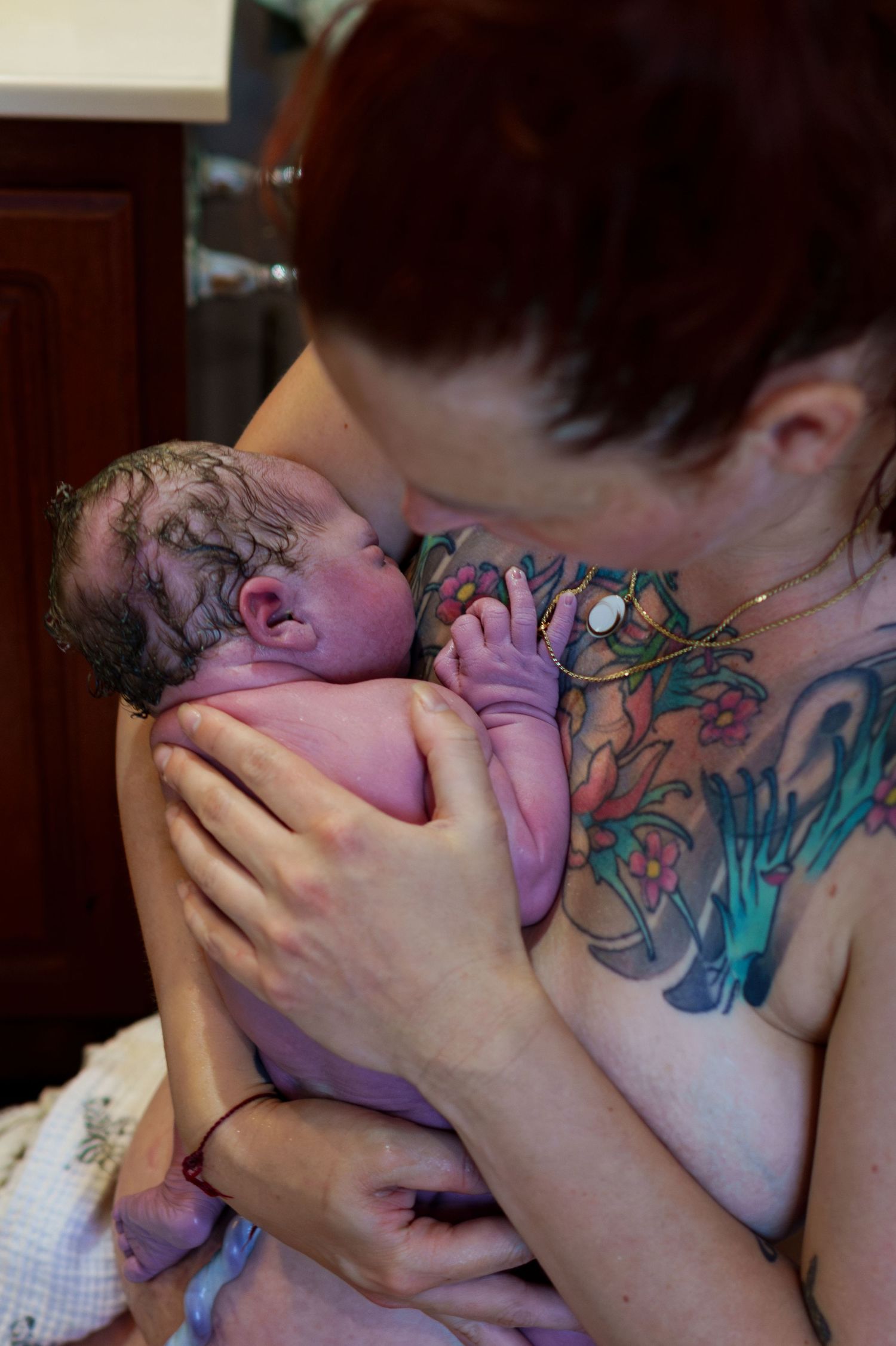 Sequence of intimate close-up photos showing tattooed figures embracing in dim lighting.