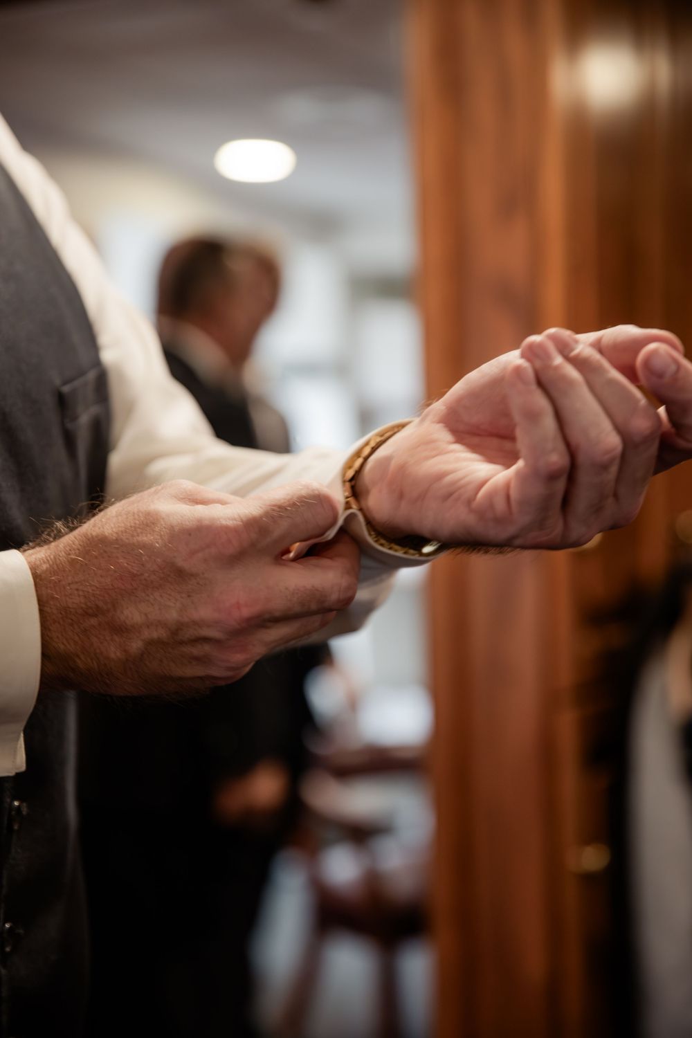 Close-up sequence of hands exchanging wedding rings during a marriage ceremony in a warm indoor setting.