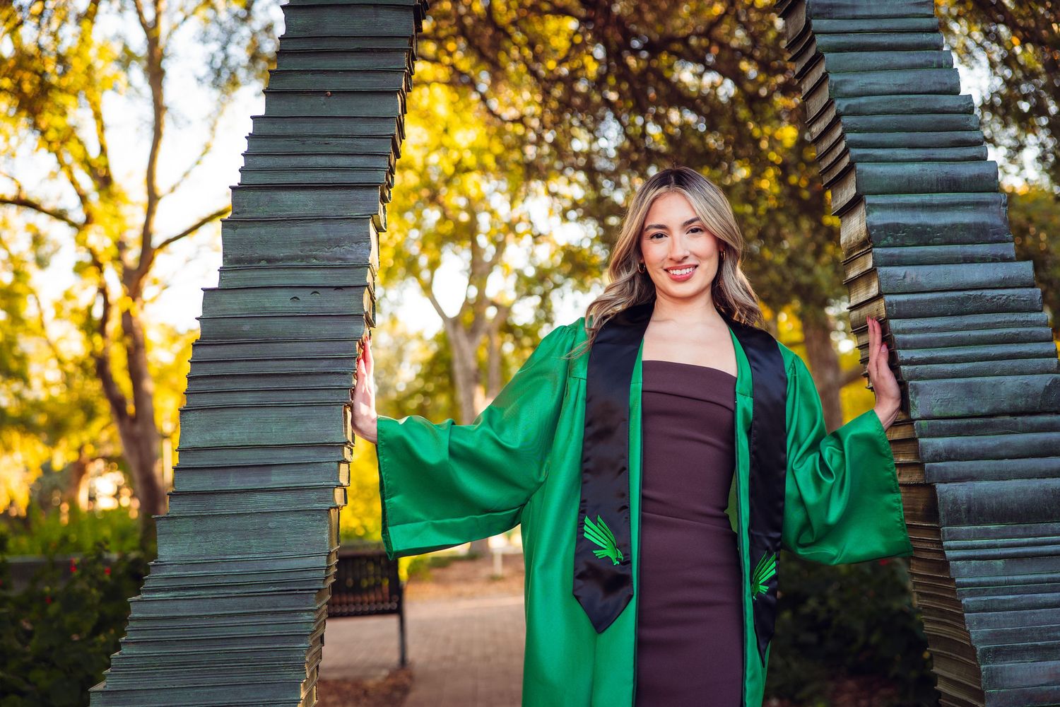Graduation photos featuring green architectural elements and warm autumn lighting. UNT Graduate Portraits by Eric Aaberg Photography in DFW.