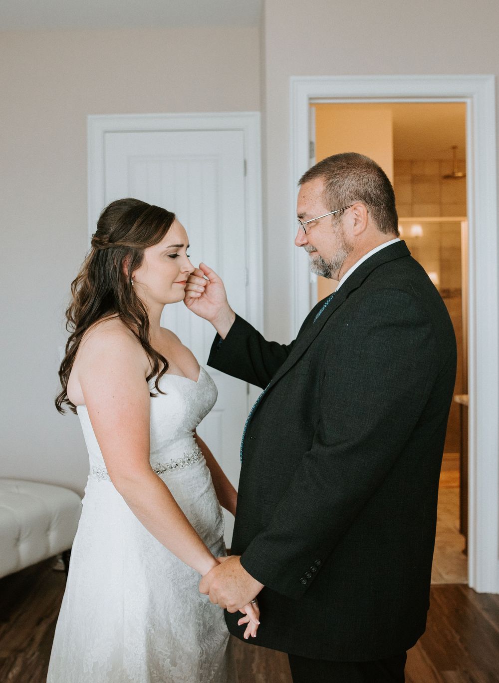 An emotional moment between two people during a wedding as they share a tender gesture.