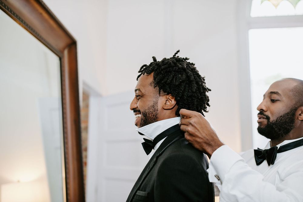 A collage of four photos showing a person looking at themselves in a mirror while styling their hair.