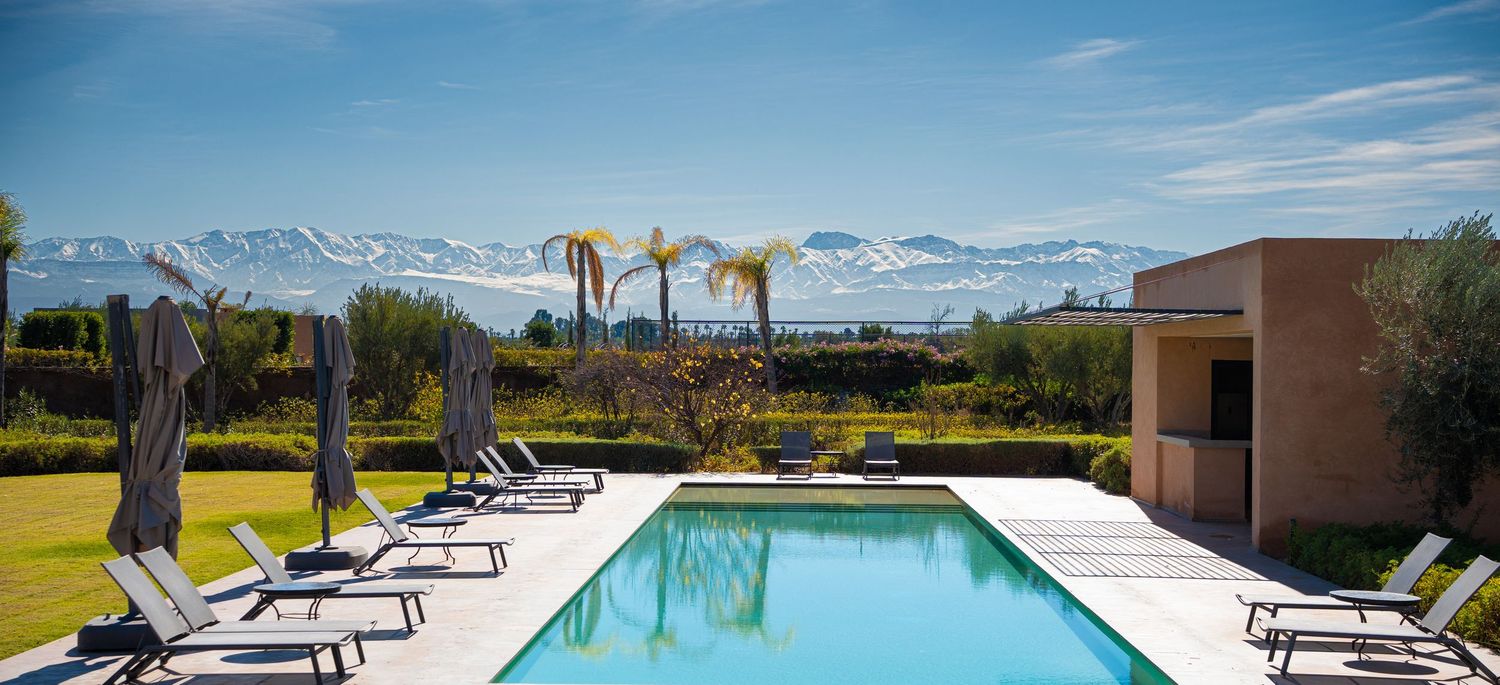 Panoramic collage of luxury resort amenities showing mountain views, pool loungers, and infinity pool overlooking scenery.