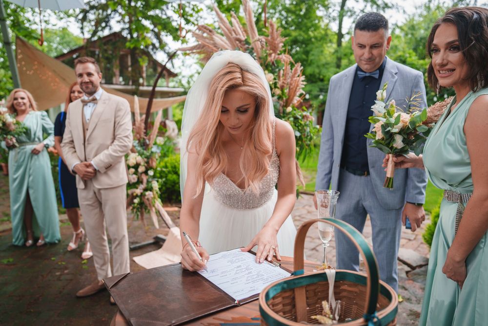 Wedding guests gather outdoors in pastel and neutral attire for a garden celebration.
