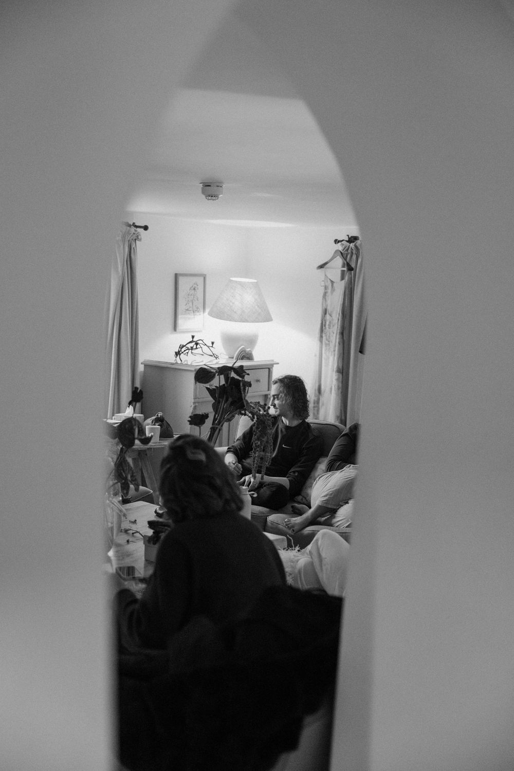 Black and white photo of wedding guests gathered in a cozy room.