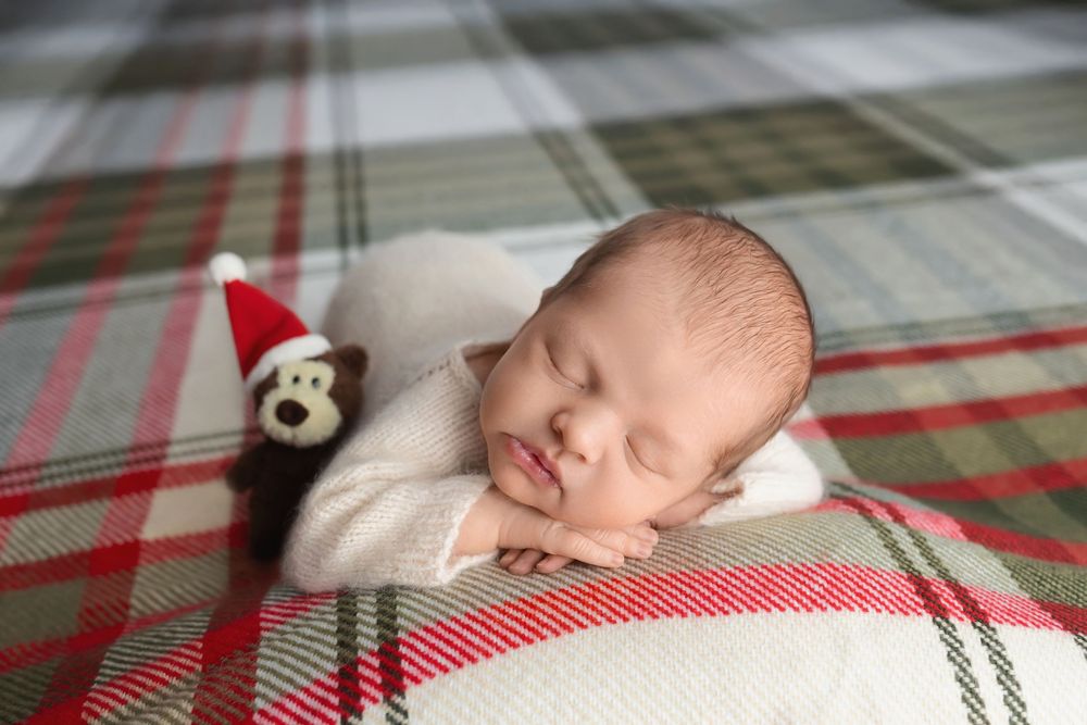Newborn baby on plaid background, taken by Jen Knightstep, Photographer
