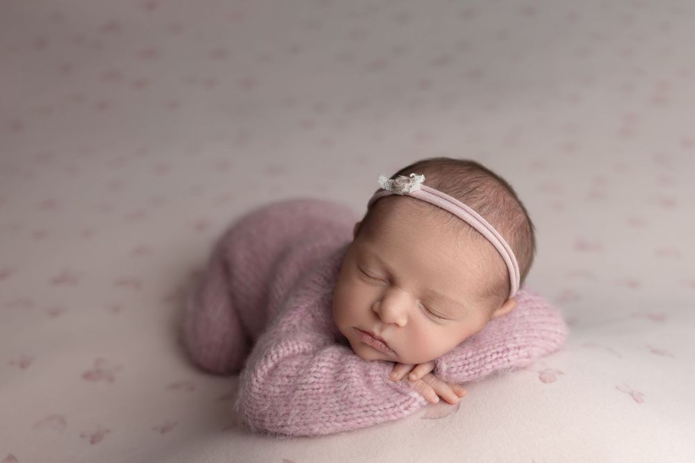 Newborn baby on pink butterfly background, taken by Jen Knightstep, Photographer