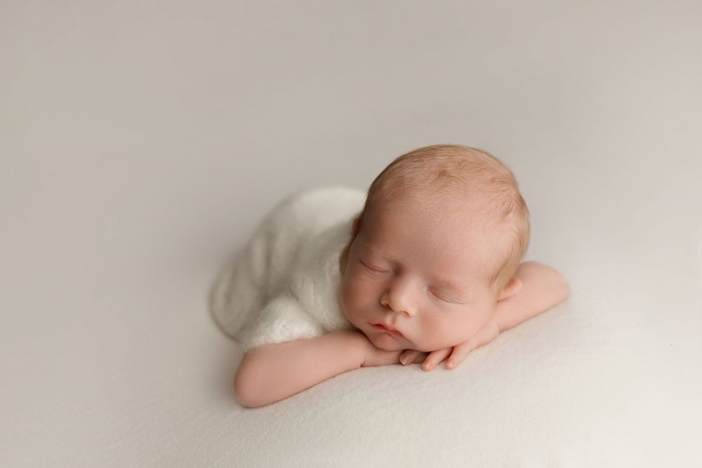 Newborn baby on cream background, taken by Jen Knightstep, Photographer