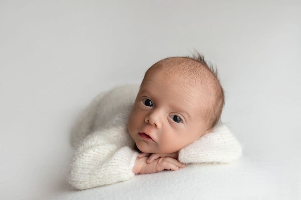 Newborn boy on white background with open eyes, taken by Jen Knightstep, Photographer