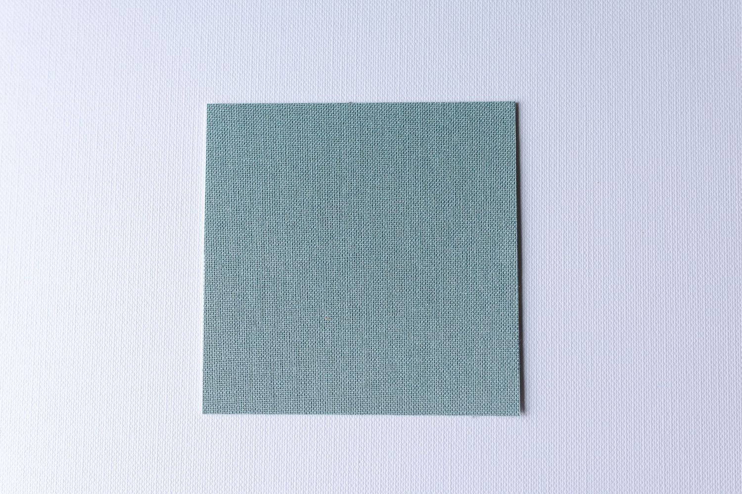 Several pieces of blue denim fabric samples arranged in a row against a light gray background.