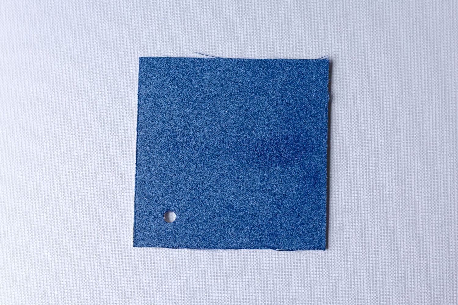 Several pieces of blue denim fabric samples arranged in a row against a light gray background.
