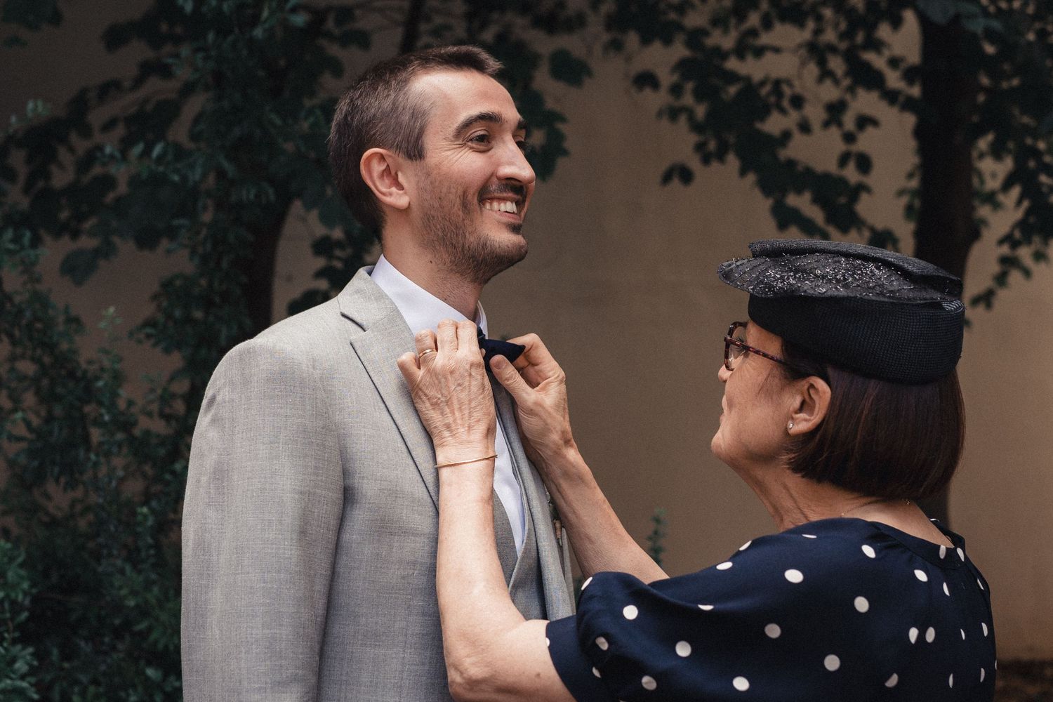 A couple shares a joyful moment together during a wedding photoshoot in an outdoor garden setting.