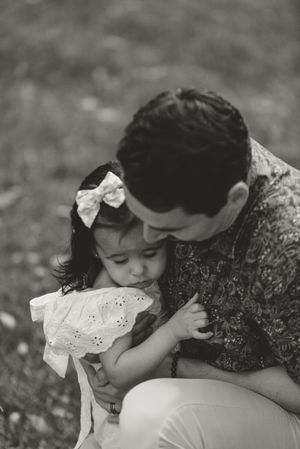 A tender black and white photograph showing an intimate family moment in a close embrace.