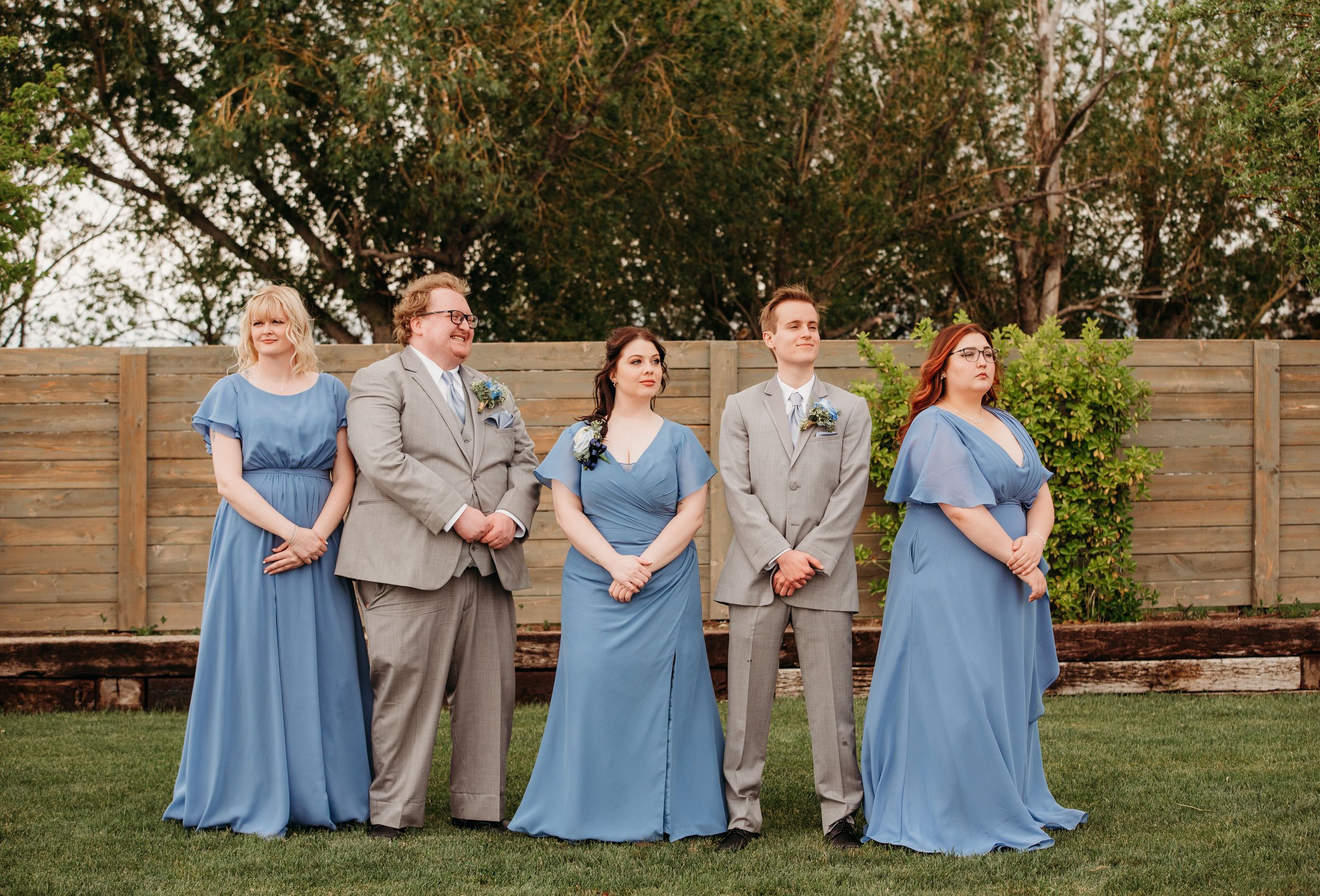 Wedding party in light blue dresses and gray suits poses playfully in a series of outdoor photos.