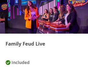 A game show set with contestants at podiums and a host in an orange blazer standing under colorful stage lighting.