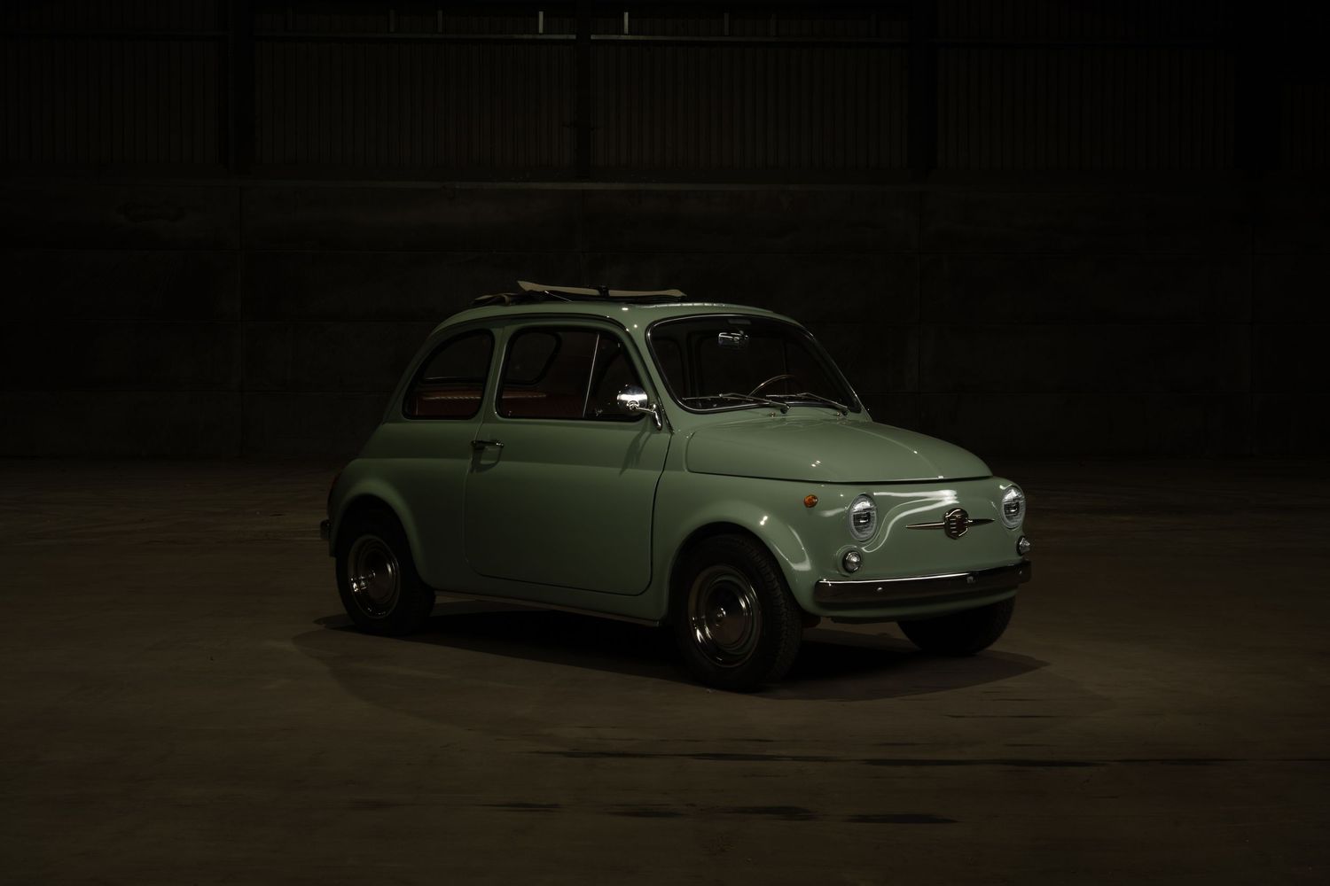Vintage Volkswagen Beetle car shown from multiple angles in dark moody lighting against black background.