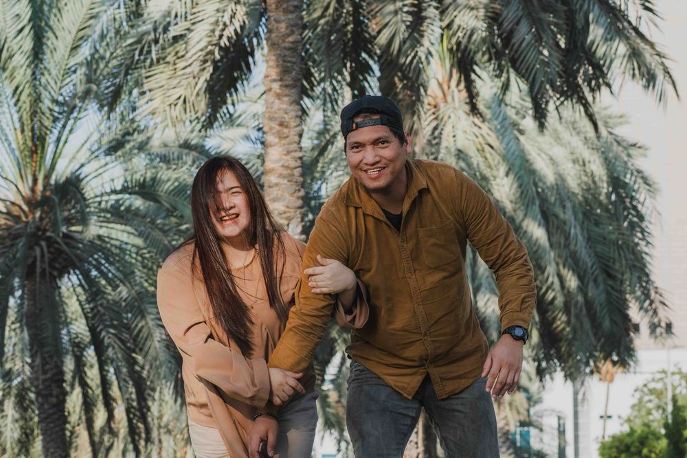 Couple in Abu Dhabi park, palm trees background. Lifestyle Family & Couple Photographer in Abu Dhabi.
