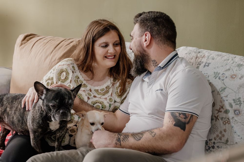 A couple relaxes on a couch at home with their cat in a series of intimate lifestyle photos.