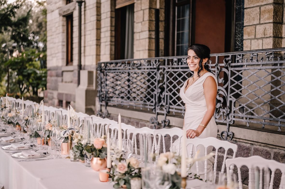 Bride admiring long wedding dinner table overlooking Lake Iseo