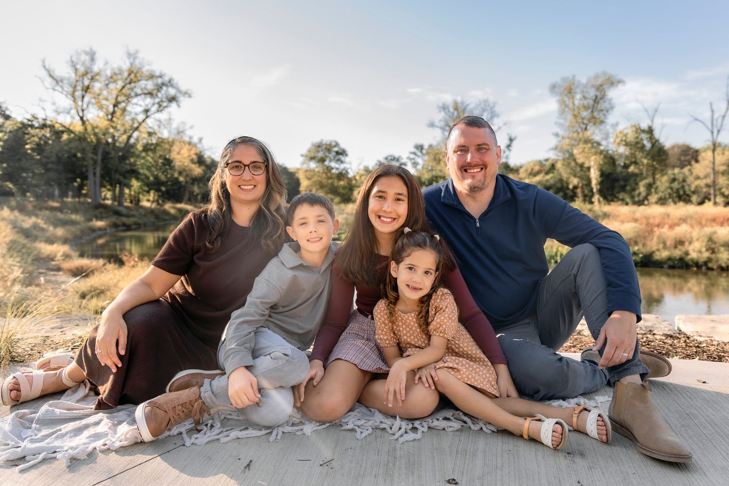 A series of outdoor family portraits showing joyful moments together by a lake during golden hour.