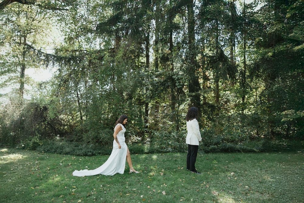 A couple shares romantic moments in a sunlit forest setting during a wedding photo session.