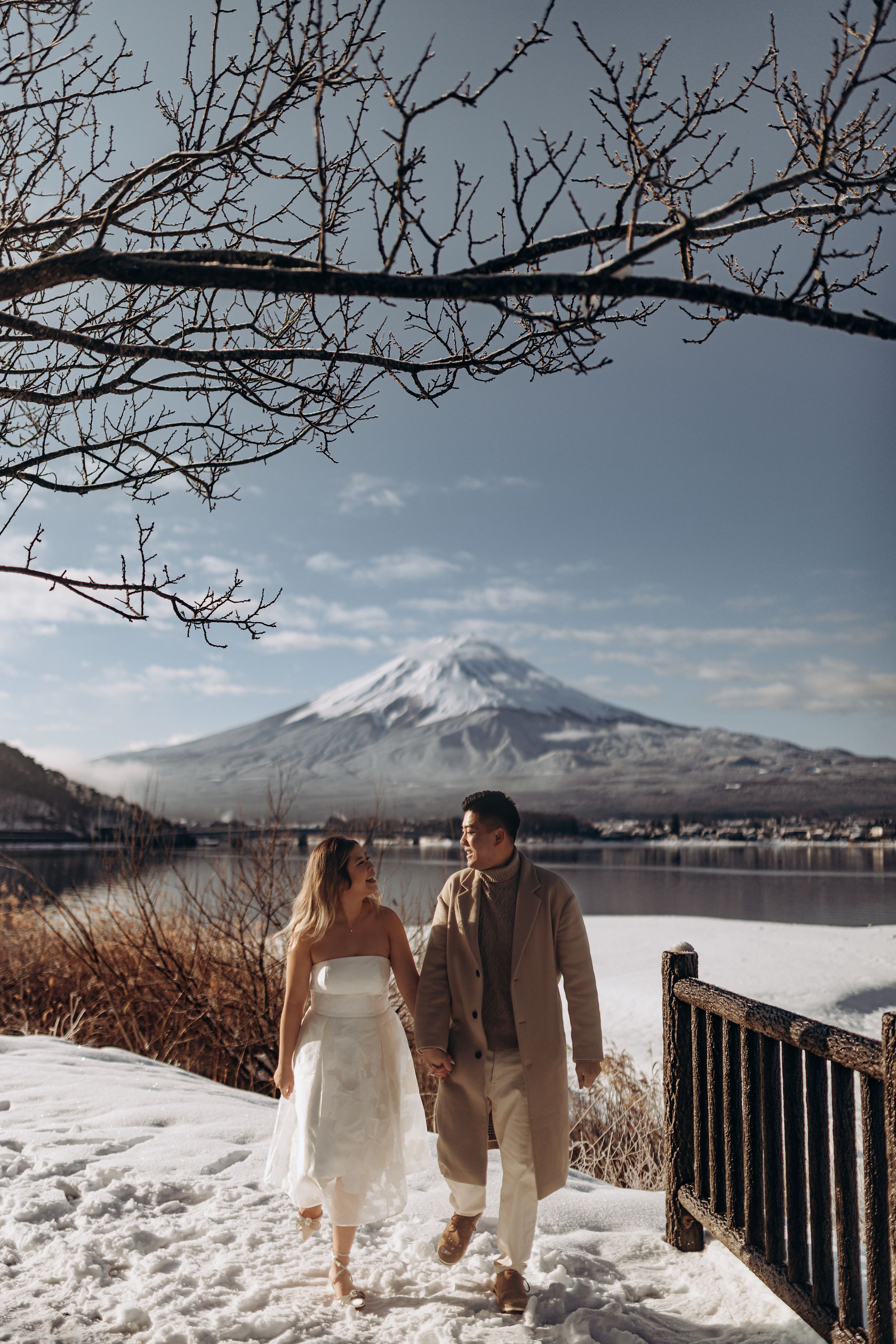 A scenic winter wedding photoshoot with Mount Fuji and Lake Yamanaka creating a stunning snow-covered backdrop.