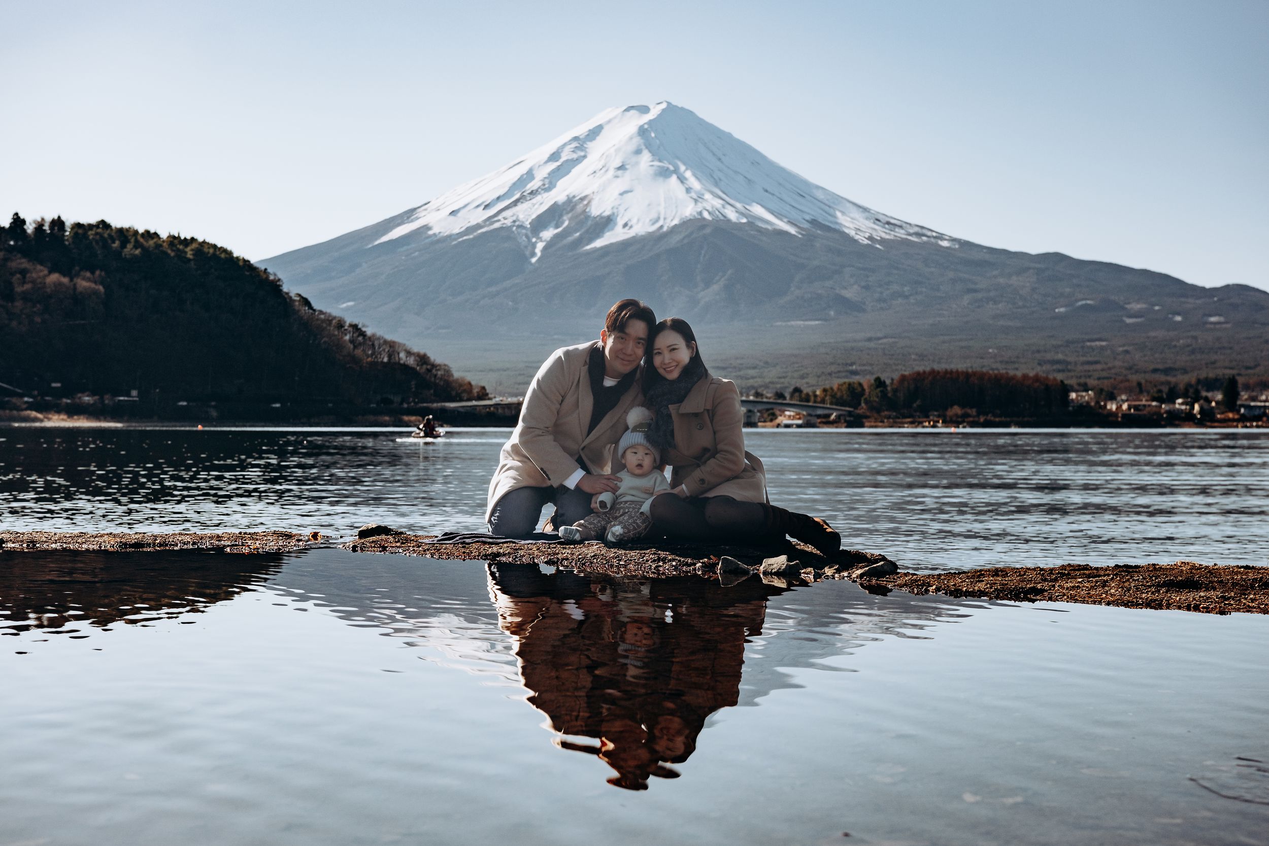 A romantic moment captured at the edge of Lake Kawaguchiko with snow-capped Mount Fuji in the distance.
