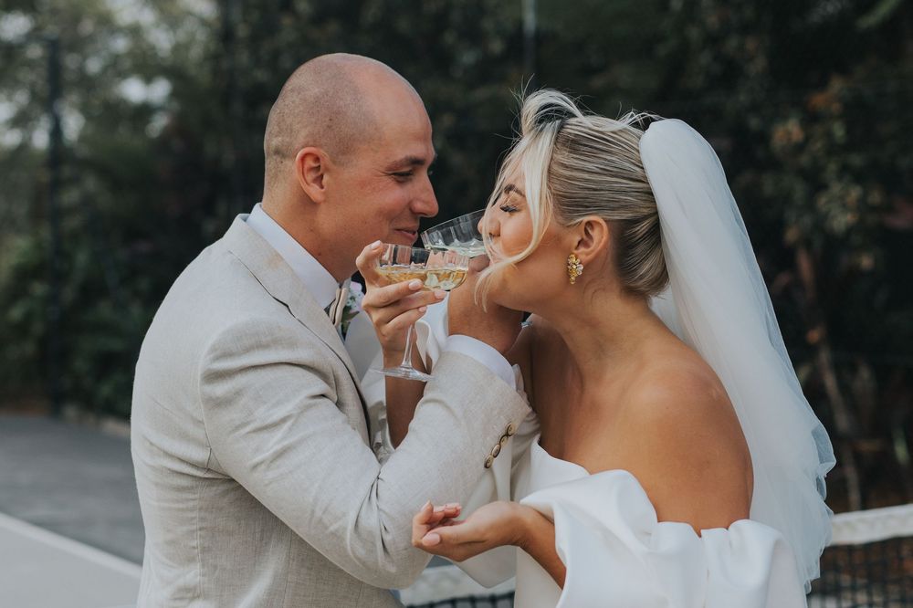 A romantic wedding couple shares intimate moments in a series of outdoor photos wearing elegant grey and white attire.