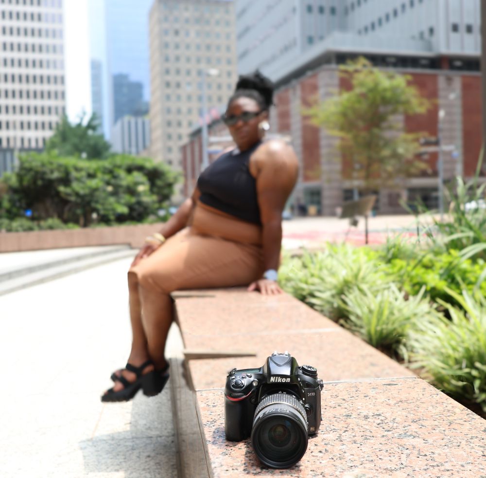 Professional camera equipment positioned on urban sidewalk with buildings in background.