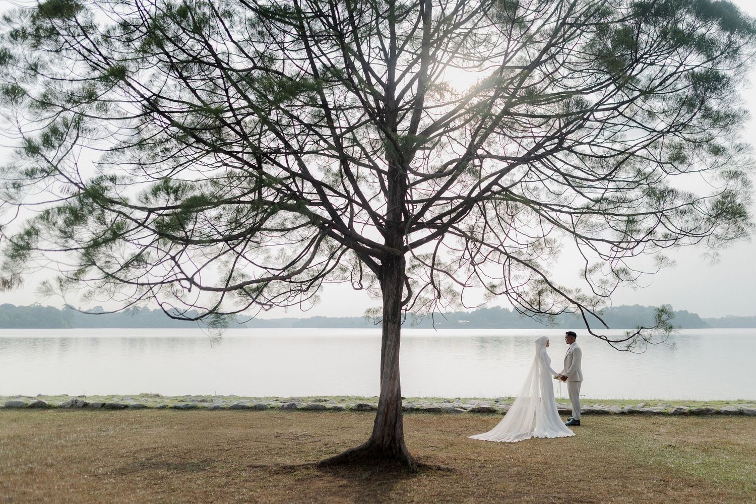 Modern wedding venue decorated with suspended circular lights and white floral installations.