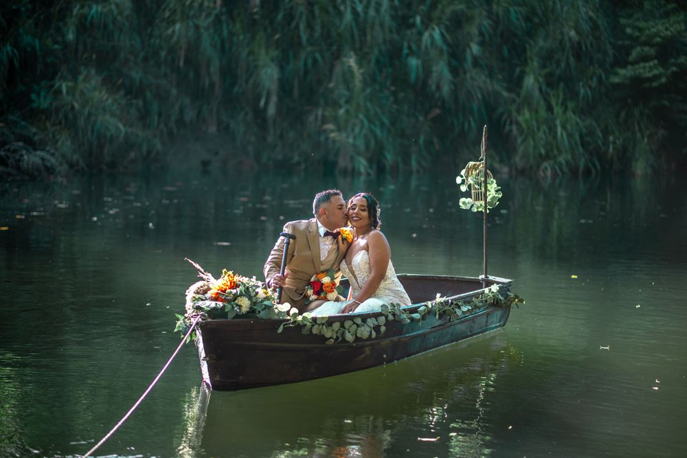 A romantic paddleboat ride on a tranquil lake surrounded by lush greenery at sunset.