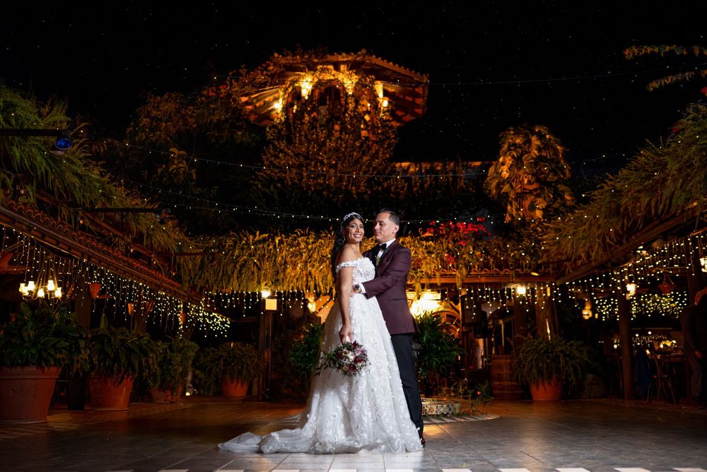 Twinkling lights illuminate an outdoor evening wedding reception.