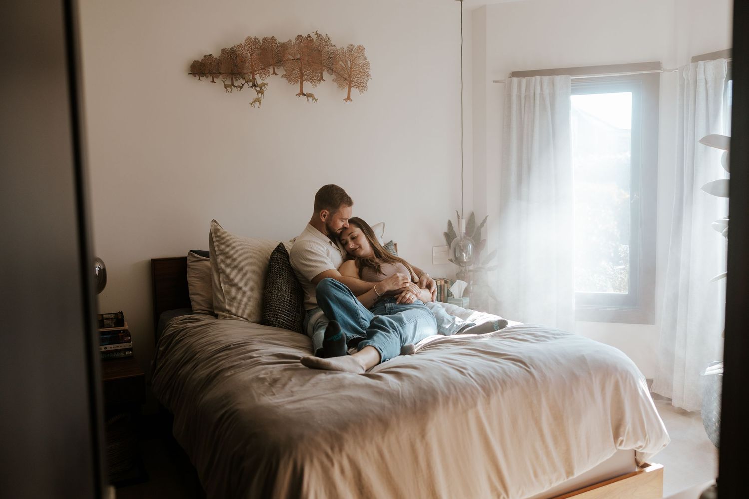 couple snuggling on their bed in their San Francisco apartment for their in-home engagement photos