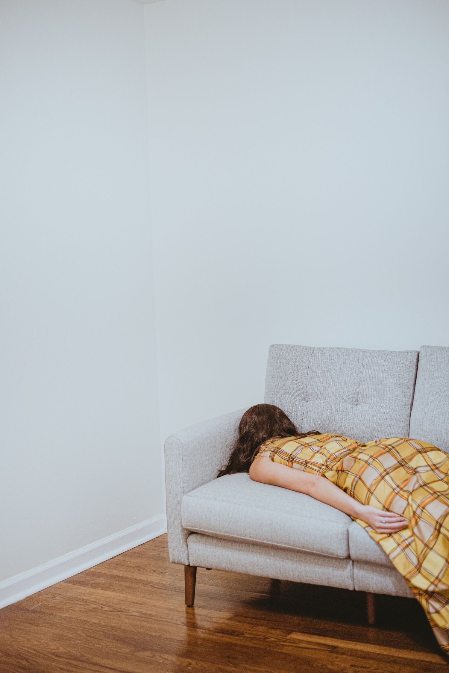 A portrait of a girl lying face down on a couch.
