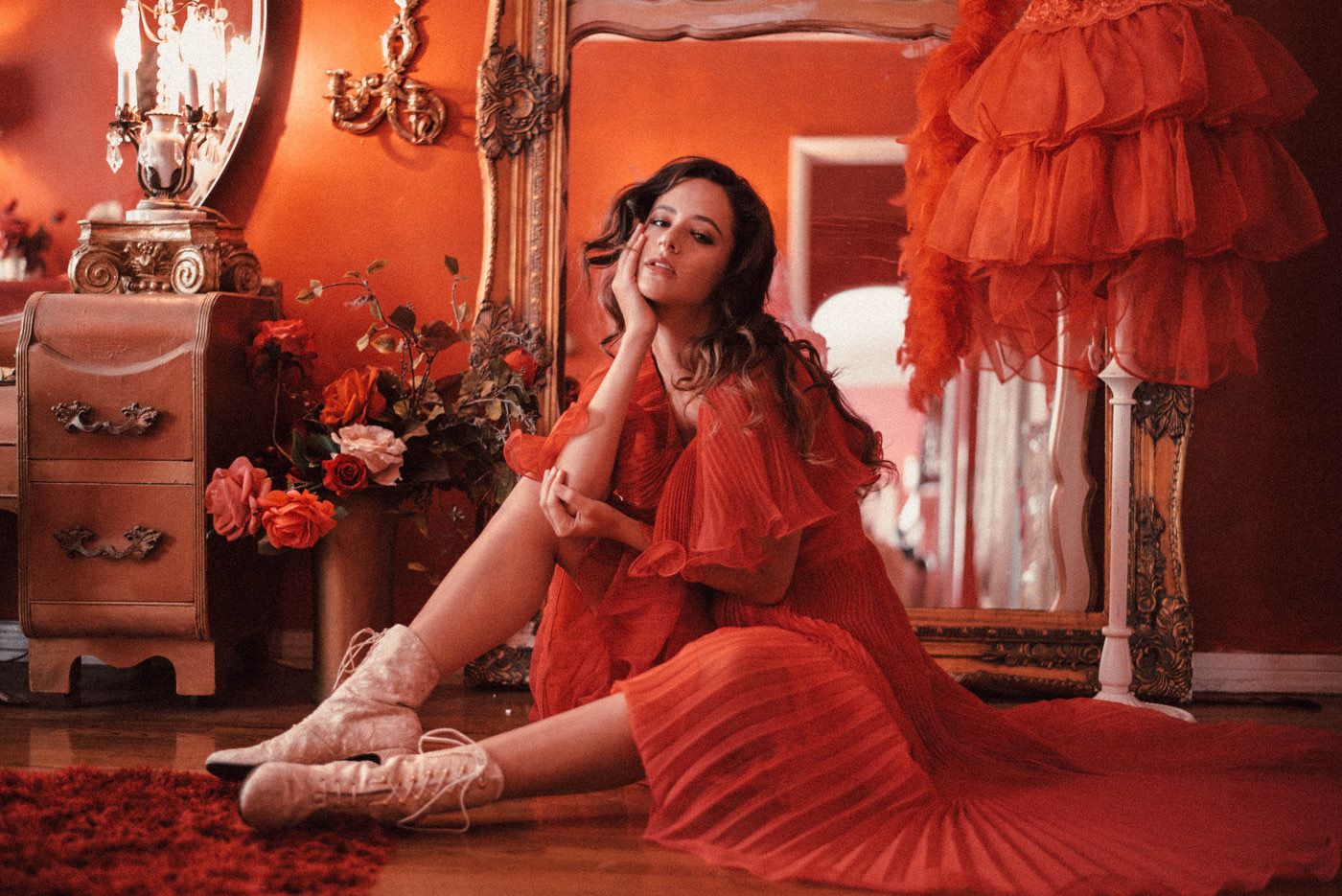 A portrait of a girl in a red dress in a red room.