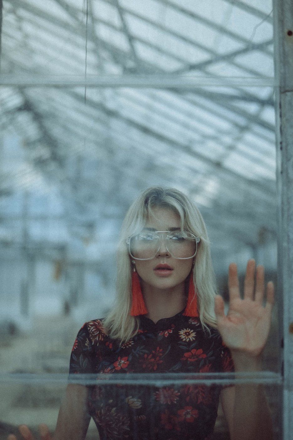 A portrait of a girl behind a glass door.