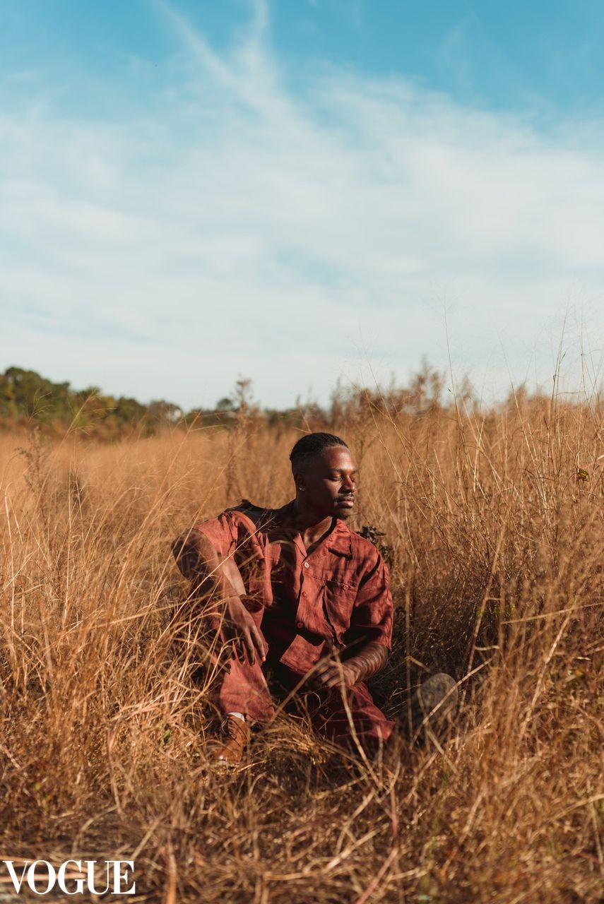 A portrait of a man in a field.