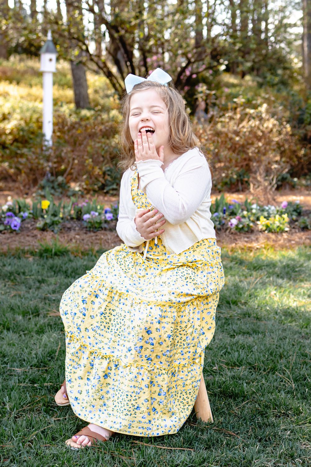 a child sitting in a garden laughing