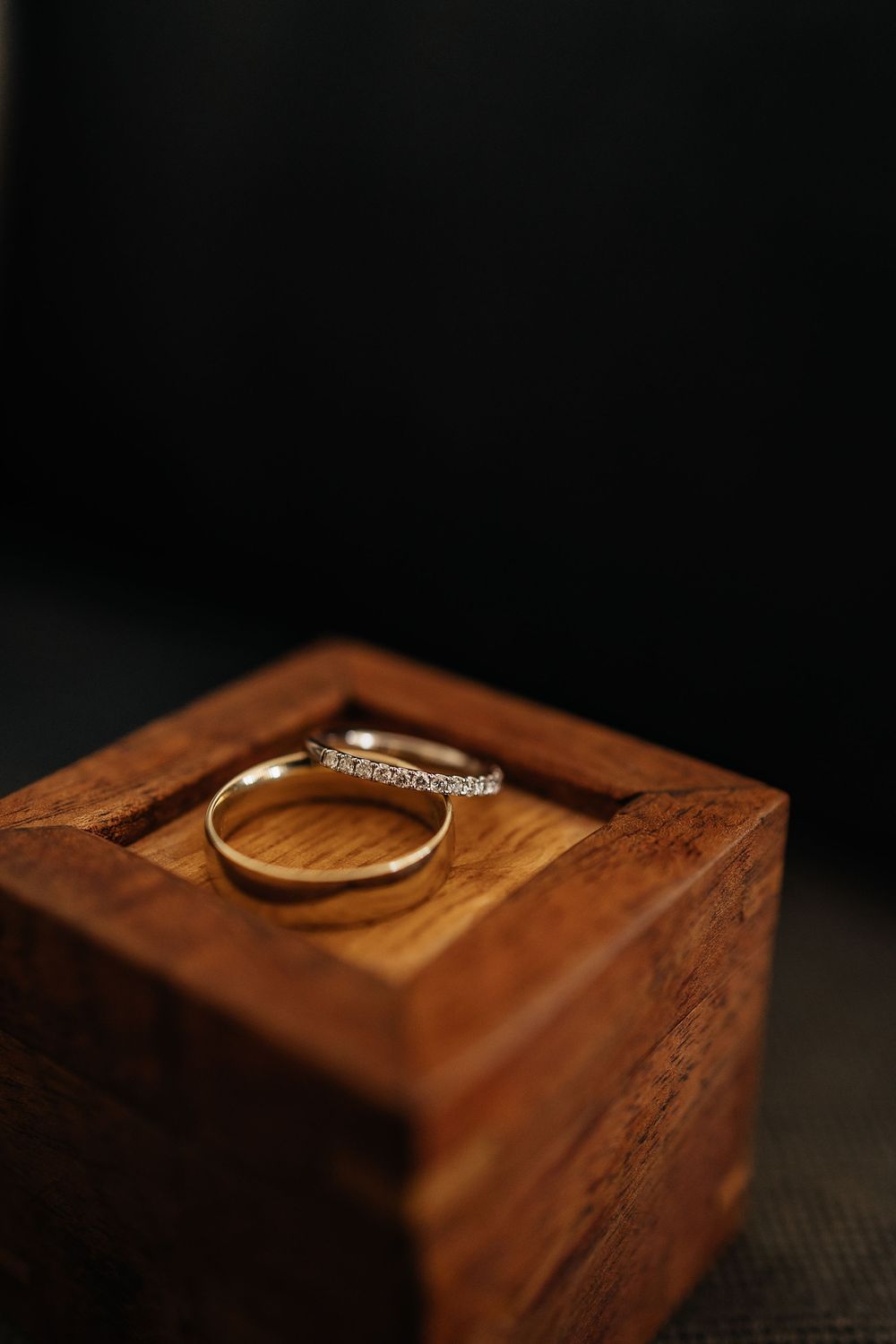 A series of close-up photos showing a gold wedding ring casting dramatic shadows on a wooden surface.