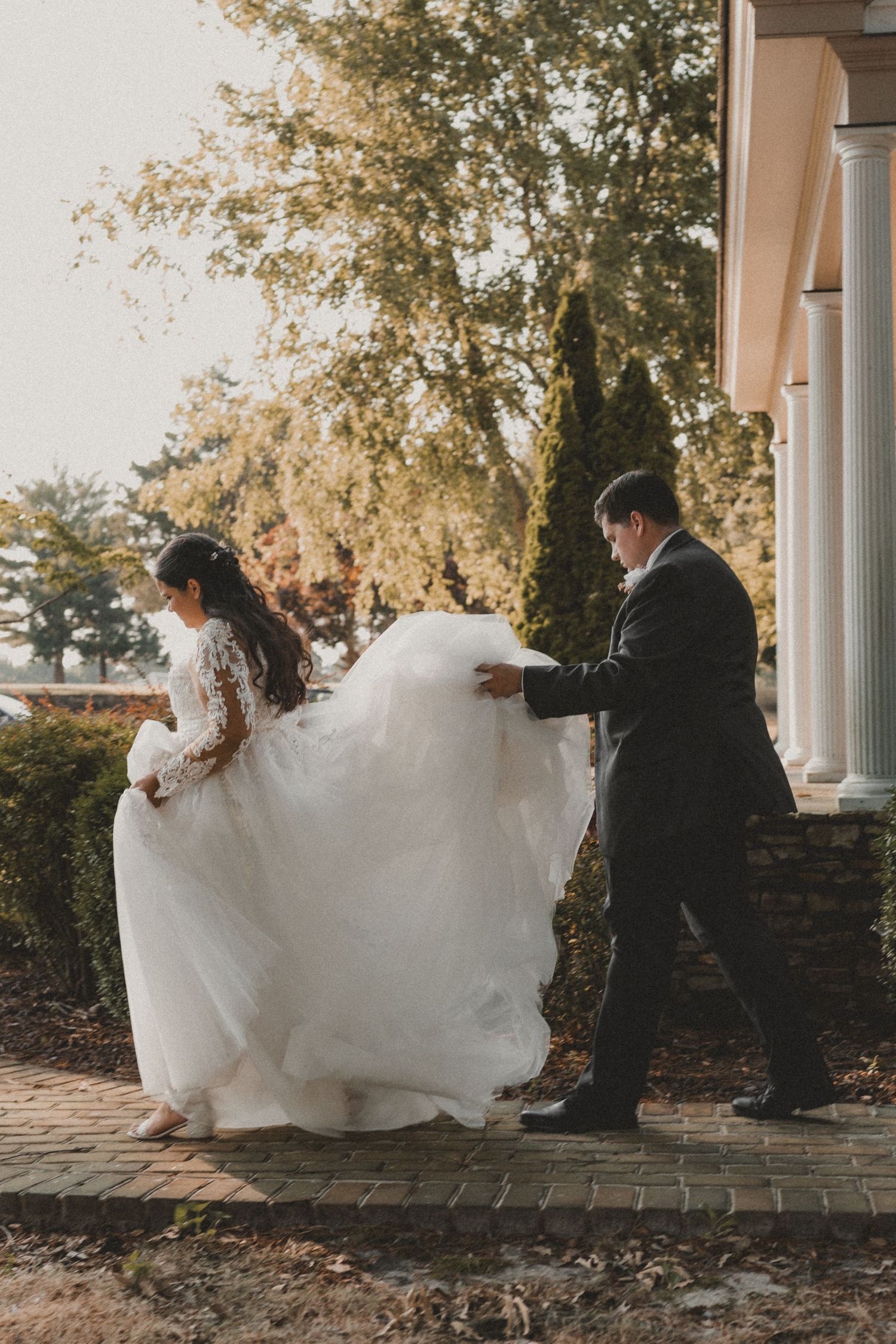 husband and wife looking at each other at a wedding with barn in the background