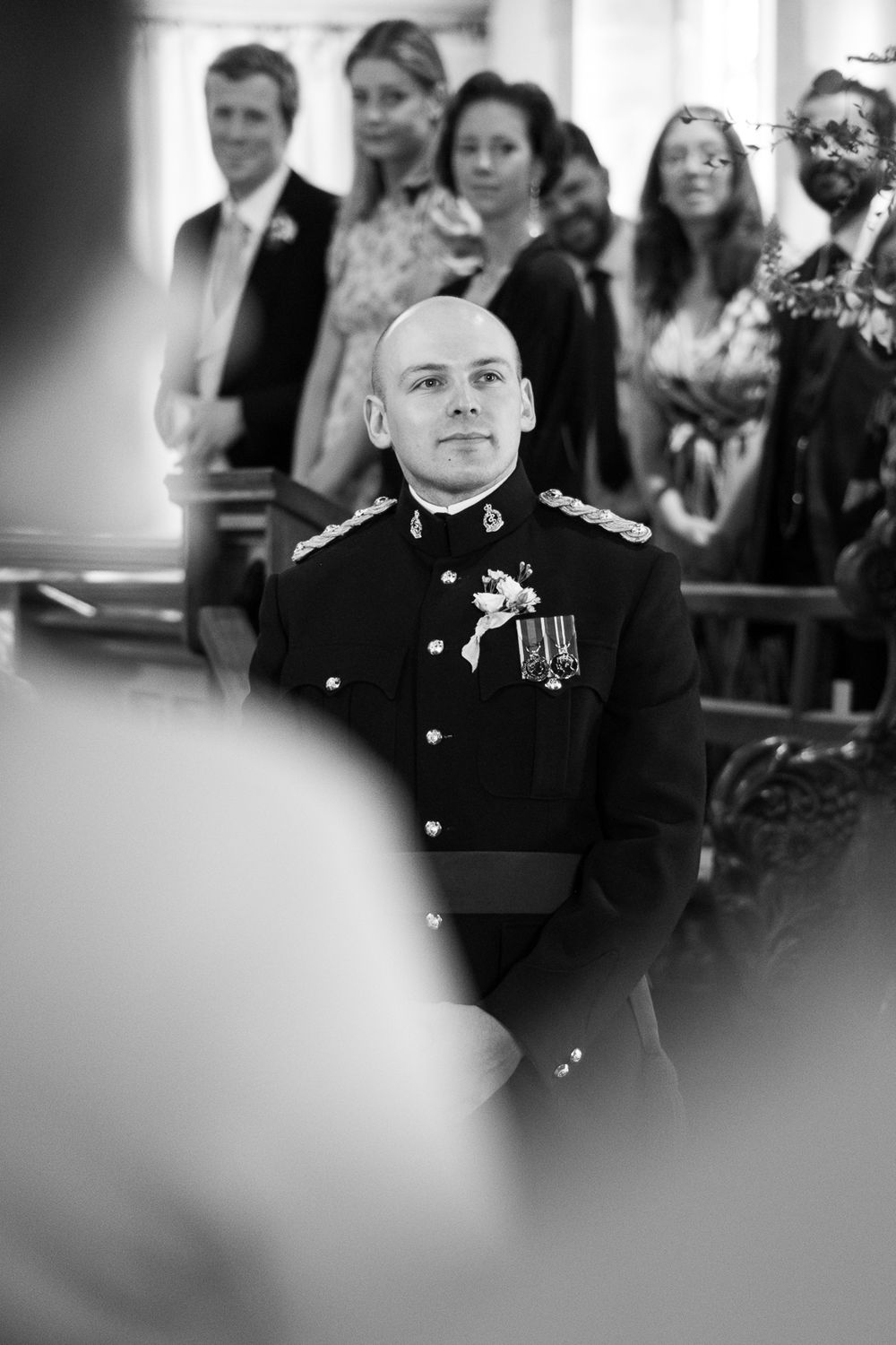 Black and white photo of uniformed military personnel in formal dress with medals during a ceremony.