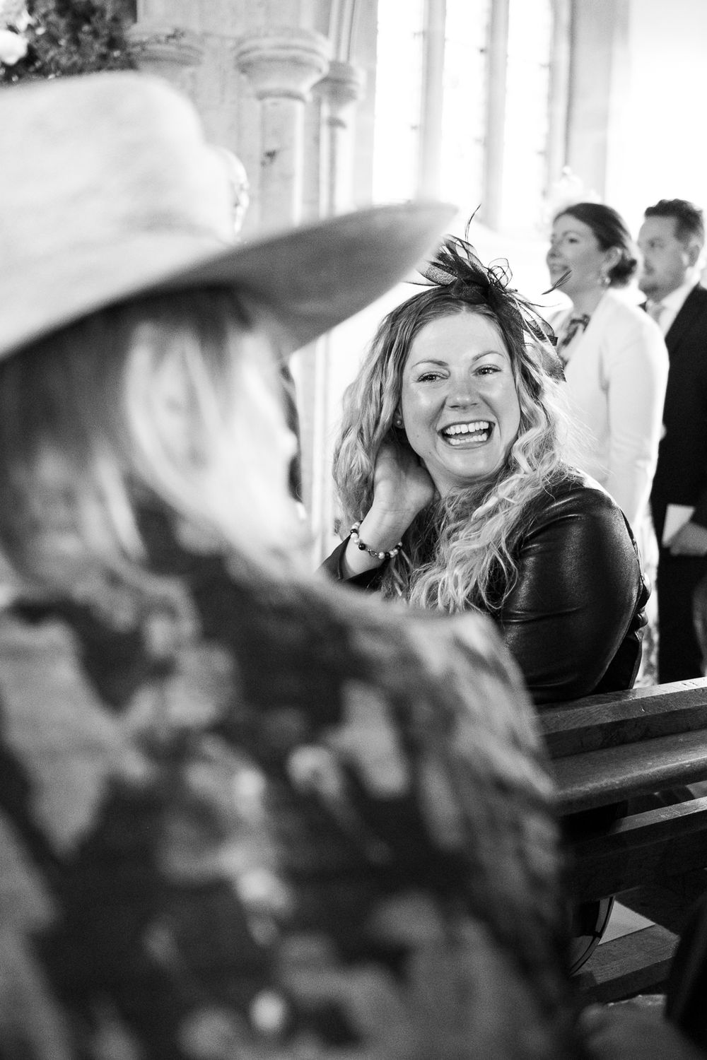 A joyful candid moment captured in black and white shows laughter and happiness during a church gathering.