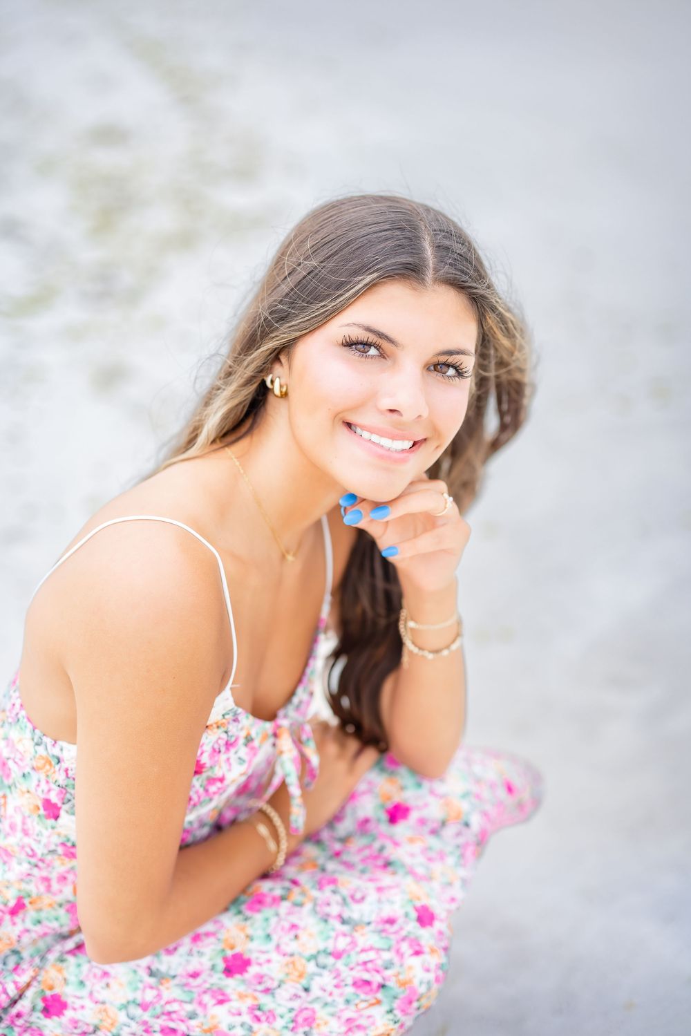Four photos of a person in a white and pink floral dress posing against a light background.