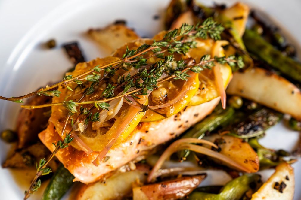 Grilled shrimp with fresh herbs and asparagus in a light sauce.