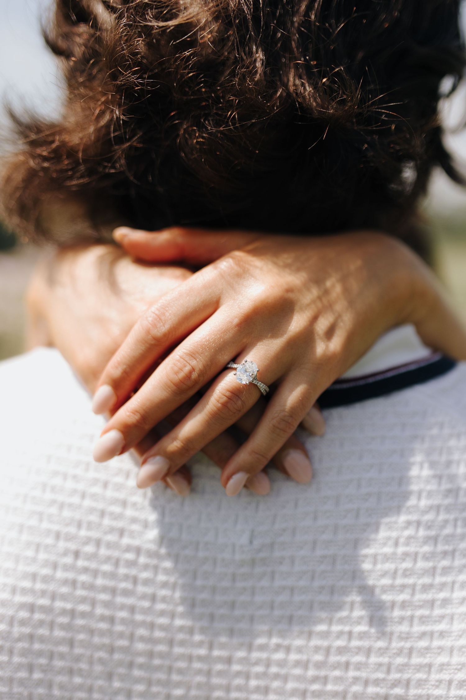 Close-up on Brooke's arms around Martin's neck with a detail shot of gorgeous engagement ring.